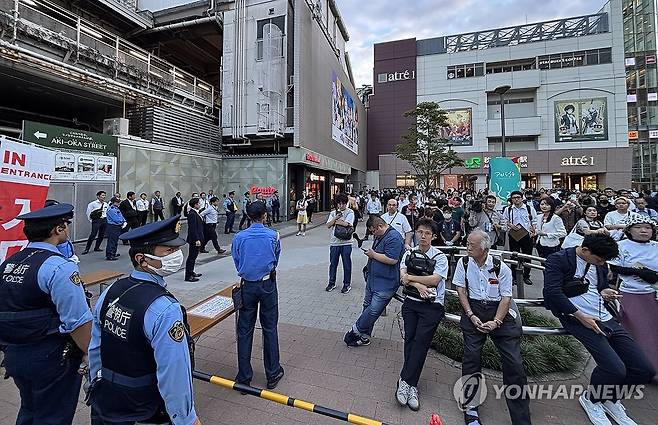 자민당 총재 선거 연설회 보는 사람들 (도쿄=연합뉴스) 박상현 특파원 = 24일 오후 일본 도쿄 아키하바라역 근처에서 시민들이 삼엄한 경비 속에 열린 집권 자민당 총재 선거 연설회를 보고 있다.