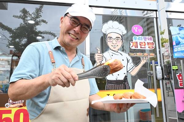 이화수 '우리동네 계란빵 이화수 아저씨' 대표가 가게 앞에서 계란빵을 들고 있다. /김구연 기자 sajin@idomin.com