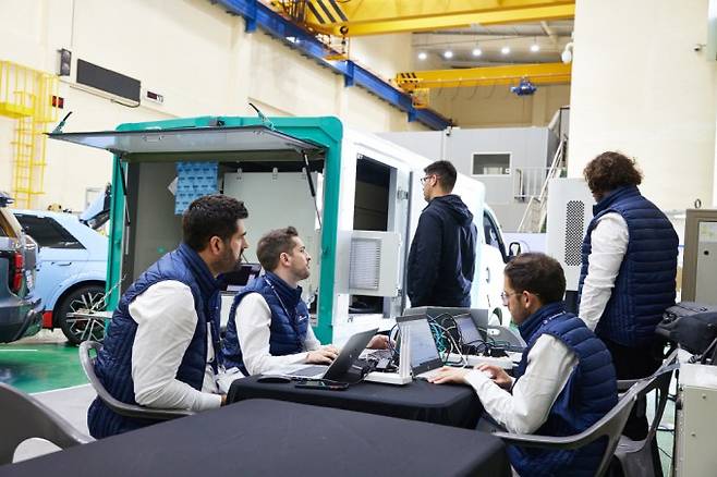 KERI가 기업 관계자들과 함께 전기차와 충전기를 교차해 상호운용성을 시험하고 있다. KERI 제공.