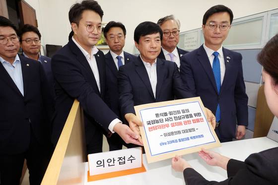 더불어민주당 3대특검 종합대응 특별위원회 이성윤 의원 등이 18일 서울 여의도 국회 의안과에 '윤석열·김건희 등의 국정농단 사건 진상규명을 위한 전담재판부 설치에 관한 법률안'을 제출하고 있다. 연합뉴스