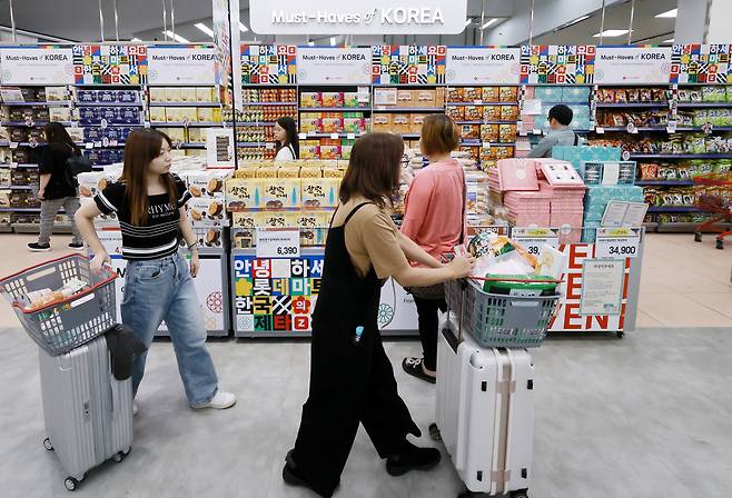 Tourists select Korean snacks at a mart in Seoul on Monday. (Yonhap)
