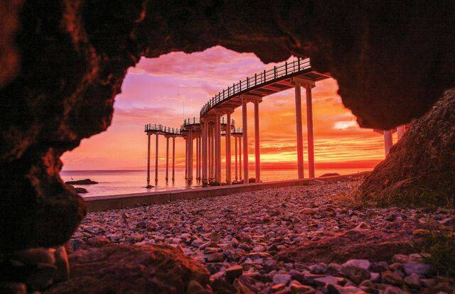 경북 포항시 북구 청하면 ‘이가리 닻 전망대’ 너머로 동해 아침노을이 붉게 드리워져 있다. 바다로 뻗은 닻 모양 전망대의 끝은 독도를 가리킨다.