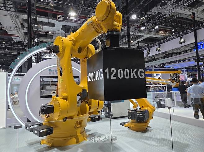 24일 중국 상하이 국제컨벤션센터에서 열린 ‘2025 로봇박람회’에서 중국 기업 ‘에스툰’이 선보인 다관절 로봇팔이 1.2t 무게의 추를 들어 올리고 있다. ﻿박람회는 27일까지 이어진다.
