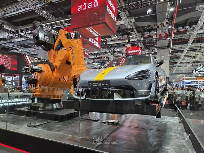 24일 중국 상하이 국제컨벤션센터에서 열린 ‘2025 로봇박람회’에서 중국 기업 ‘차이푸’의 초대형 대관절 로봇팔 ‘알프틱 5000KG’가 자동차를 들어 올리고 있다.