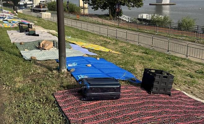 서울 여의도 한강공원 일대에서 열리는 ‘서울세계불꽃축제 2025’를 하루 앞둔 26일 행사장 주변에 시민들이 돗자리를 펴두고 자리를 선점하고 있다. /온라인 커뮤니티