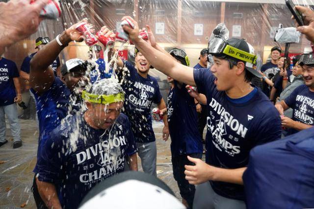 오타니 쇼헤이(오른쪽)가 26일 미국 애리조나주 피닉스 체이스필드에서 열린 애리조나와의 원정 경기에서 내셔널지구 서부지구 우승을 확정한 뒤 동료들과 샴페인을 터트리고 있다. 피닉스=AP 연합뉴스