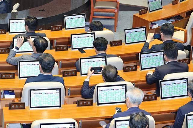 26일 서울 여의도 국회에서 열린 제429회국회(정기회) 9차 본회의에서 검찰청 폐지를 골자로 한 정부조직법 개정안이 통과되자 의원들이 스마트폰으로 사진을 남기고 있다. 뉴스1