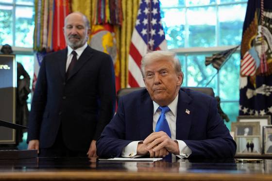 U.S. President Donald Trump looks on, with U.S. Secretary of Commerce Howard Lutnick standing by his side, in the Oval Office at the White House in Washington, D.C. on Sept. 19. [REUTERS/YONHAP]