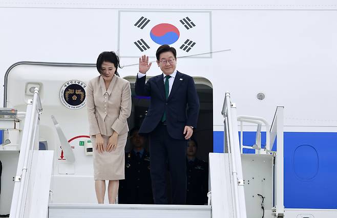 미국 방문 일정을 마친 이재명 대통령과 김혜경 여사가 25일(현지시간) 뉴욕 JFK공항 공군 1호기에서 인사하고 있다. [연합]