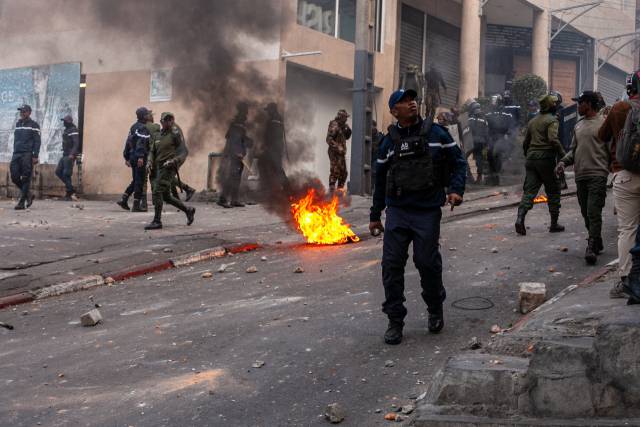 마다가스카르 안타나나리보에서 열린 시위 도중 치안 부대 요원들이 시위대가 불을 붙인 타이어 옆을 지나가고 있다. EPA 연합뉴스