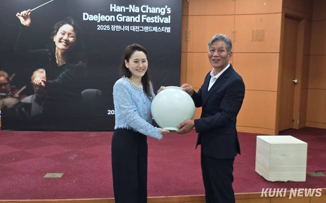 석봉 한도현 도예 작가가 장한나 예술감독에게 받은 감동에 감사해 백자 달 항아리로 답례하고 있다. 사진=명정삼 기자