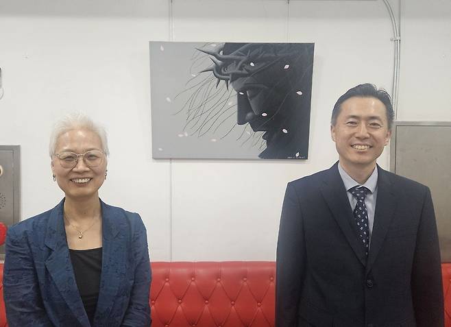 서울 서초구 빛교회 2층에 걸린 무기수의 그림 앞에서 양태우(오른쪽) 목사와 방영옥 작가가 웃고 있다. 신은정 기자