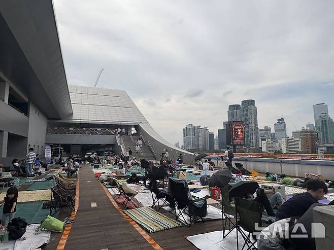 [서울=뉴시스]최은수 기자=2025 서울세계불꽃축제가 열린 27일 오후, 서울 동작구 노량진수산시장 3층 옥외 데크. 여의도 63빌딩을 정면으로 조망할 수 있는 이곳에서 시민들이 돗자리를 펴고 불꽃놀이를 기다리고 있다. 2025.09.27