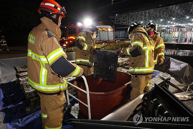 불에 탄 리튬이온 배터리 소화수조로 옮기는 소방대원 (대전=연합뉴스) 배재만 기자 = 27일 밤 대전 유성구 국가정보자원관리원 화재 현장에서 소방대원이 소화수조에 불에 탄 리튬이온 배터리를 옮기고 있다. 2025.9.27 scoop@yna.co.kr