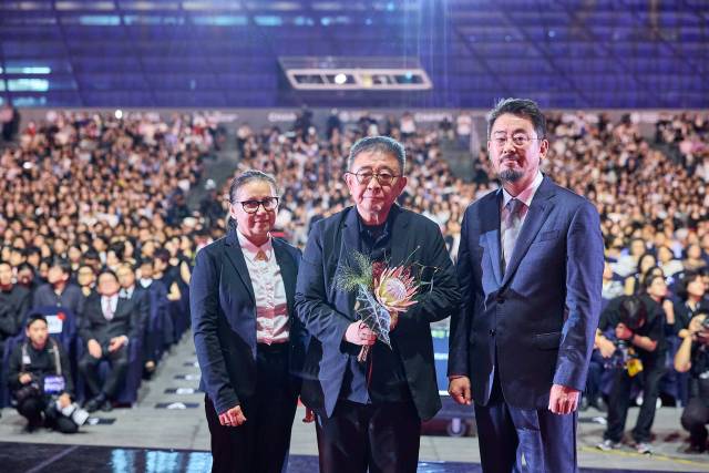 지난 26일 오후 부산 해운대구 영화의전당 야외무대에서 열린 제30회 부산국제영화제 폐막식에서 '루오무의 황혼'을 연출한 장률(가운데) 감독이 경쟁부문 부산 어워드 대상을 수상했다. 오른쪽은 나홍진 심사위원장, 왼쪽은 시상자로 나선 일디코 에네디 감독. BIFF 제공