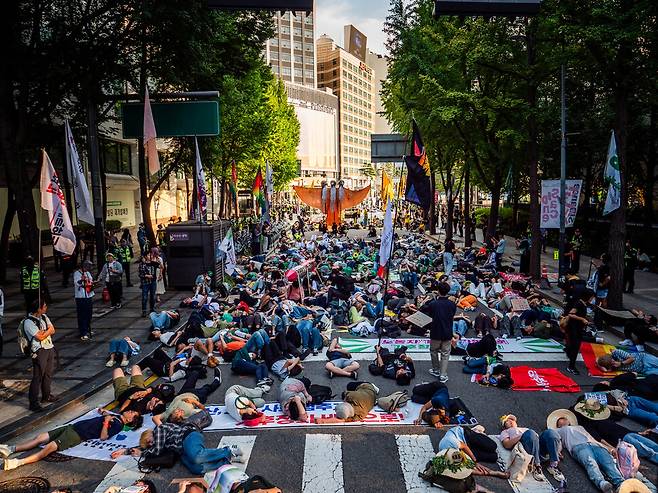27일 오후 서울에서 열린 2025년 기후정의행진 참가자들이 서울시청 부근에서 거리에 누워 시위하고 있다. 기후정의행진조직위원회 제공