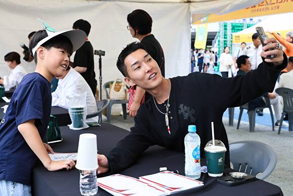 우상혁 선수가 지난 27일 '스포츠 스타와 함께하는 시민 참여 축제'에서 어린이 팬과 사진을 찍고 있다. [사진=용인특례시]