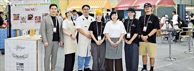 박상화 푸드트래블 대표(맨 왼쪽)가 플라이 아시아에 마련한 식음 브랜드관 앞에서 5개 로컬 브랜드 사장들과 함께 포즈를 취하고 있다.  부산기술창업투자원 제공