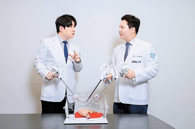 분당서울대병원 박영석(오른쪽)·전동재 교수가 복강경 기구 ‘아티센셜’을 작동해 보며 수술 방식을 논의하고 있다. 김동하 객원기자