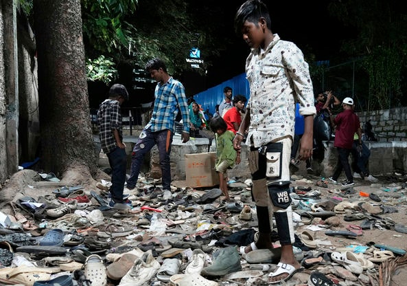 지난 27일(현지시간) 30여명이 압사한 인도 남부의 한 선거 유세현장에서 사고 후 흩어진 신발들을 시민들이 뒤지고 있다. AP뉴시스