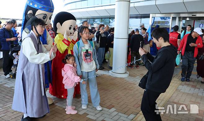 [인천=뉴시스] 전진환 기자 = 중국인 단체관광객에 대한 무비자 입국 시행 첫날인 29일 오전 인천 연수구 인천항 크루즈터미널에서 중국인 단체 크루즈 관광객이 입국해 기념촬영을 하고 있다.  2025.09.29. amin2@newsis.com