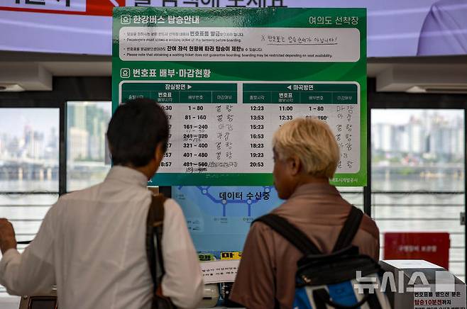 [서울=뉴시스] 정병혁 기자 = 29일 서울 마포구 한강버스 여의도선착장을 찾은 여행객이 한강버스 탑승안내문을 바라보고 있다.한강버스가 운항 열흘 만에 승객 탑승을 중단했다. 지난 18일 정식운항 시작부터 잇따른 고장과 날씨 영향으로 운항에 차질을 빚더니 결국 한 달간 정밀 점검이라는 결단을 내렸다. 서울시는 29일부터 약 한 달간 한강버스 승객 탑승을 일시 중단하고, 성능 고도화와 안정화를 위한 '무승객 시범운항'으로 전환한다고 밝혔다. 2025.09.29. jhope@newsis.com