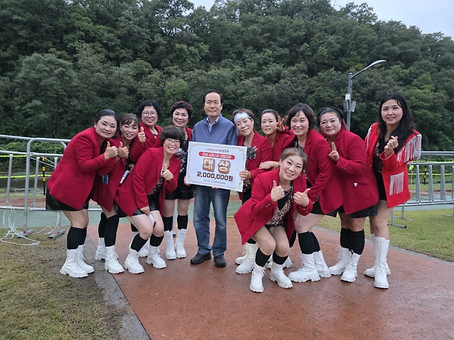 ▲ 28일 경북 의성군 남대천 구봉공원에서 열린 제8회 의성슈퍼푸드 마늘축제 '의성 슈퍼스타 선발대회' 시상식을 마친 뒤, 김주수 의성군수(가운데)와 대상에 오른 가음면 '아름소리 난타' 팀(회장 신말숙·왼쪽 세 번째부터)이 무대 옆에서 상금 현판을 들고 기념촬영을 하고 있다. 가음면 아름소리 난타