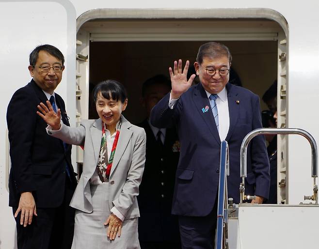 Japanese Prime Minister Shigeru Ishiba (right) and his wife Yoshiko Ishiba (center) depart Haneda International Airport in Tokyo to fly to Busan on Tuesday. (Yonhap)