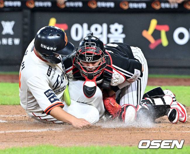 [OSEN=대전, 민경훈 기자] 29일 오후 대전 한화생명볼파크에서 2025 신한 SOL Bank KBO리그&nbsp;한화 이글스와&nbsp;LG 트윈스의 경기가 열렸다.한화는&nbsp;정우주, LG는&nbsp;임찬규를 선발 투수로 내세웠다.3회말 2사 주자 2루 한화 노시환의 좌익수 앞 안타때 한화 문현빈이 홈으로 몸을 날렸다. LG 포수 박동원이 좌익수 문성주의 홈 송구를 놓치는 포구 실책을 범하면서 한화 문현빈의 득점이 인정됐다.  2025.09.29 /rumi@osen.co.kr