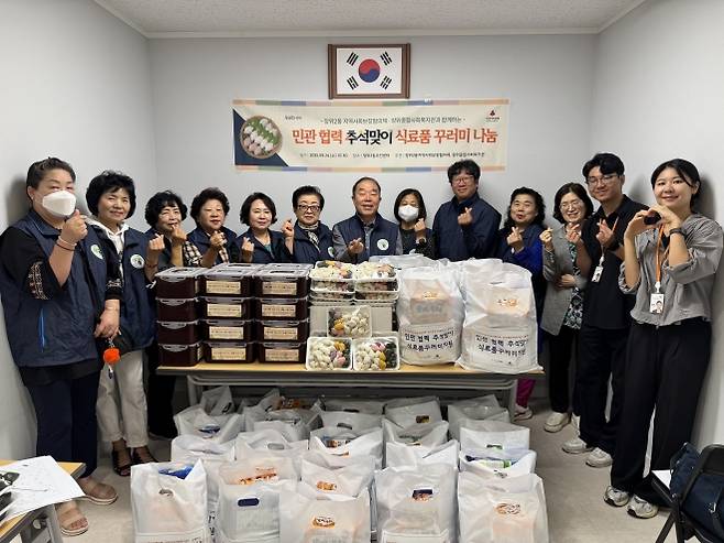 서울 성북구 장위2동 주민센터가 지난 24일 지역 단체들과 함께 저소득 40가구에 식료품 꾸러미를 전달하기 전에 관계자들이 기념촬영을 하고 있다. 성북구 제공