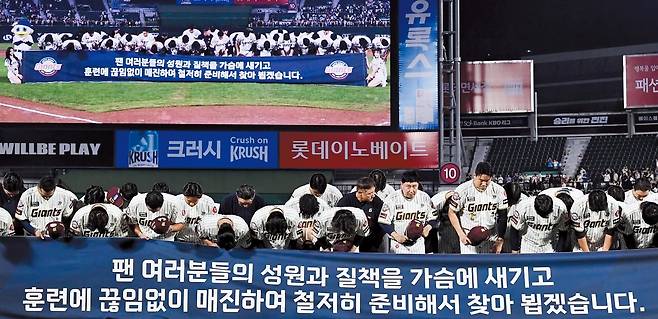 프로야구 롯데 선수단이 지난 26일 부산 사직야구장에서 삼성을 상대로 올 시즌 마지막 홈경기를 마친 뒤 팬들에게 고개를 숙여 인사하고 있다. 8년 연속 포스트 시즌 진출에 실패한 롯데는 “팬들의 질책을 가슴에 새기고 훈련에 끊임없이 매진하겠다”는 내용의 현수막을 펼쳐 들었다./송정헌 스포츠조선 기자