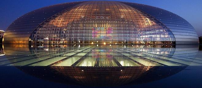 빛의 반사 효과를 이용한 중국 베이징의 오페라 극장인 국가대국원.(건축가 폴 앙드뢰) 반원 형태의 건물이 호수에 비쳐 구형으로 보인다. EPA 연합뉴스