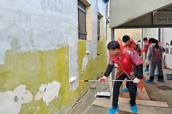 롯데건설 윤수준 영남지사장(맨 앞)과 임직원들이 아동복지시설 개선 봉사활동에 참여하고 있다 사진=롯데건설