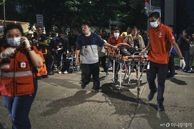 [세부=AP/뉴시스] 지난달 30일(현지 시간) 필리핀 중부 세부 해역에서 규모 6.9의 강진이 발생해 주민들이 건물 밖으로 대피한 가운데 구급대가 부상 주민을 옮기고 있다. 2025.10.01. /사진=민경찬