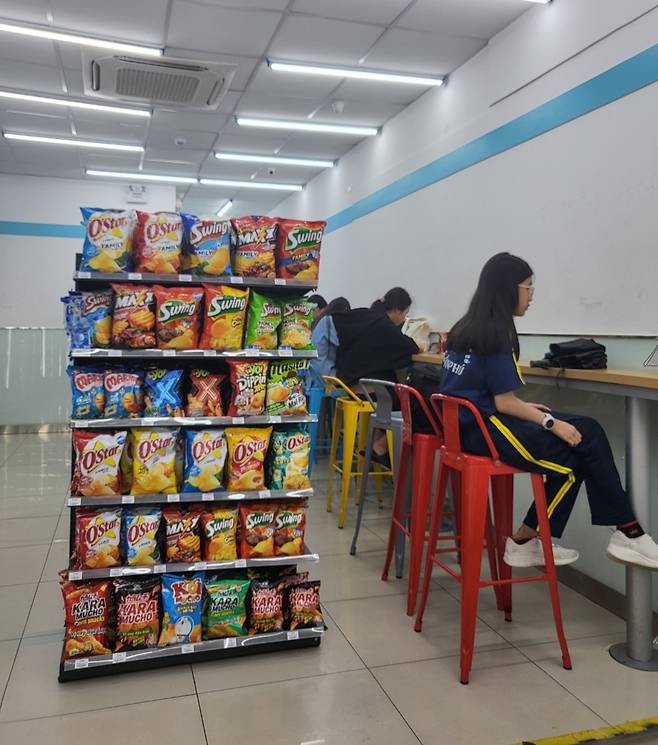 베트남 호치민시에 위치한 한 GS25 매장. 매대에는 오리온의 오스타, 스윙, 마시타 등 스낵이 빼곡이 진열돼있다. 베트남인들은 GS25 매장 의자에 앉아 음식을 먹고 마시거나 친구를 만나는 등 시간을 보낸다./사진=차현아 기자.