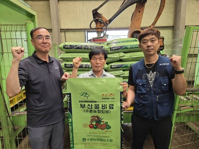 이규현 수륜농협 조합장(가운데)이 직원들과 품질 좋은 퇴비를 만들어 땅심을 살리고 환경을 지키겠다며 파이팅을 하고 있다.