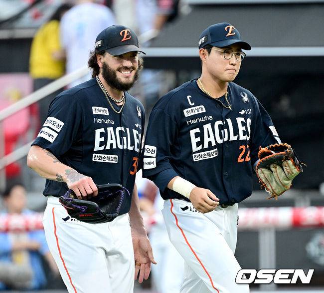 [OSEN=수원, 최규한 기자] 1회말 KT 공격을 실점없이 막아낸 한화 선발 코디 폰세가 더그아웃으로 향하며 1루수 채은성과 미소짓고 있다. 2025.07.18 / dreamer@osen.co.kr