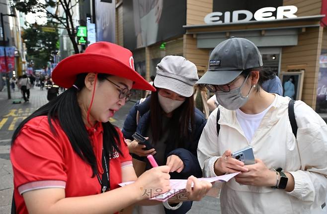 중국인 단체 관광객이 무비자 입국 허용 다음 날인 30일 서울 중구 명동 거리에서 외국인 관광객이 안내원과 대화하고 있다. 지난 29일부터 내년 6월 30일까지 국내·외 전담여행사가 모객한 3인 이상 중국인 단체관광객은 비자 없이 15일간 국내 관광을 할 수 있다. 2025.9.30 홍윤기 기자