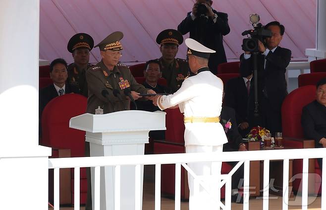 (평양 노동신문=뉴스1) = 지난 6월 구축함 강건호 진수식에서 '함선 등급 및 명명 증서'를 전달하고 있는 노광철 국방상(왼쪽). [국내에서만 사용가능. 재배포 금지. DB 금지. For Use Only in the Republic of Korea. Redistribution Prohibited] rodongphoto@news1.kr