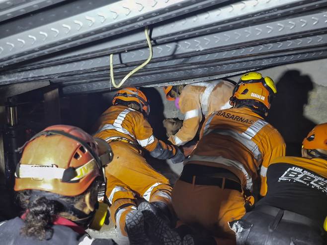 1일(현지시간) 인도네시아 동자바 시도아르조의 이슬람 기숙학교 붕괴 현장에서 구조대원들이 생존자를 구출하고 있다. EPA연합뉴스