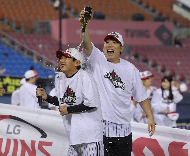 이보다 달콤한 ‘샴페인’ 또 있을까 염경엽 LG 감독(왼쪽)이 1일 잠실구장에서 정규리그 우승을 확정한 뒤 방송 인터뷰 도중 김현수가 뿌리는 샴페인에 웃음을 터뜨리고 있다. 연합뉴스