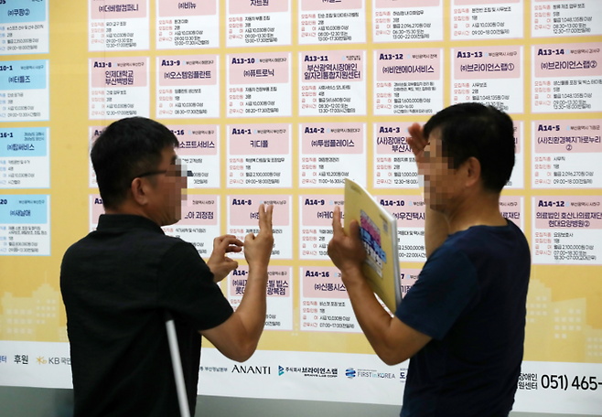 일 부산 연제구 부산시청 로비에서 열린 ‘2025 부산시 장애인 진로·취업 박람회’에서 구직자들이 채용 정보를 살펴보며 수어로 대화하고 있다. 사진과 기사는 관련 없음. [사진 = 뉴스1]