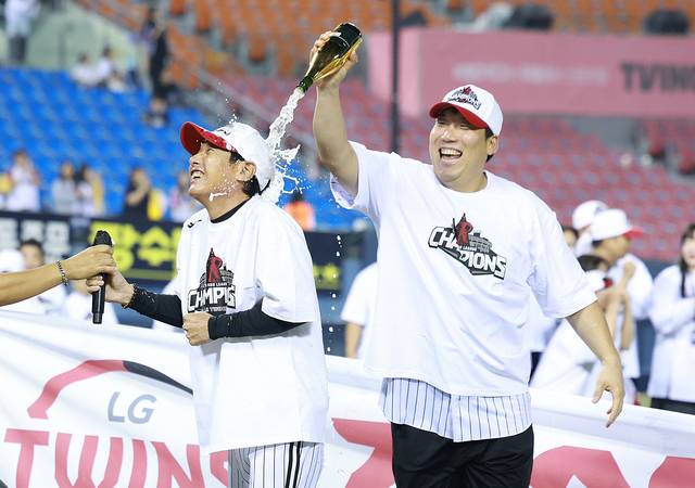 LG의 염경엽(왼쪽) 감독이 1일 잠실구장에서 정규리그 우승을 확정한 뒤 김현수로부터 샴페인 세례를 받고 있다.  뉴시스