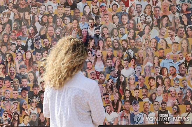 2024년 10월 6일 한 여성이 2023년 10월 7일 하마스가 이스라엘 남부 노바 음악축제 현장을 기습했을 때 숨진 피해자 사진을 보고 있다. [EPA 연합뉴스 자료사진. 재판매 및 DB 금지]
