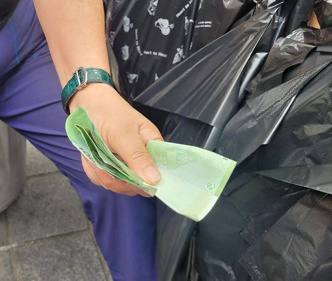 지난 1일 서울 명동에서 30년간 장사한 이혜정씨(60·여)가 하루 동안 번 돈을 보여주고 있다. 이씨의 주머니에서는 3만원이 나왔다. 공병선 기자