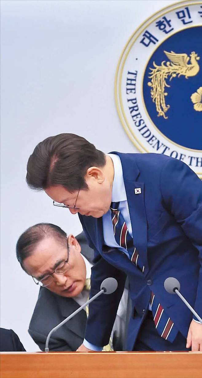 뉴시스 의자 높이 조절은 이렇게  위성락(왼쪽) 국가안보실장이 2일 서울 용산 대통령실에서 열린 수석·보좌관회의에서 이재명 대통령의 의자가 낮은 위치에 고정돼 움직이지 않자 다가가 높이를 조절해 주고 있다. 이 대통령은 자리에 앉은 뒤 웃으며 “이거 누가 관리하나. 꼭 안보실장이 나서서 해야 하는 건가”라고 말했다.