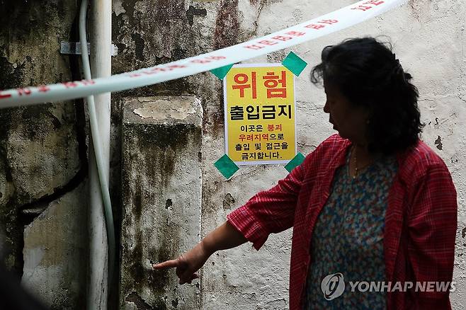 균열 생긴 보금자리 (광주=연합뉴스) 정다움 기자 = 3일 오전 광주 북구 중흥동 도시철도 2호선 공사 현장 인근 주택에서 주민이 균열을 바라보고 있다. 중흥삼거리 일대 13개 건축물은 지난달 18일 광주시의 긴급 정밀안전 점검 용역에서 긴급 보수·보강이 필요하거나 사용을 금지해야 하는 D·E등급을 받았다. 2025.10.3 daum@yna.co.kr