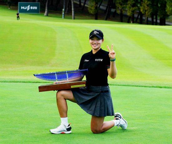 김민솔이 동부건설·한국토지신탁 챔피언십 우승 직후 트로피를 무릎 위에 올려놓고 환하게 웃고 있다. KLPGA 제공