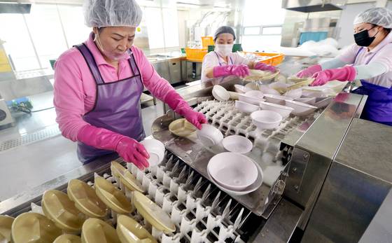 지난달 30일 충북 청주 다회용기 공공세척센터 세척라인에서 직원들이 애벌 세척을마친 그릇을 고압 세척기에 넣고 있다. 김성태 객원기자