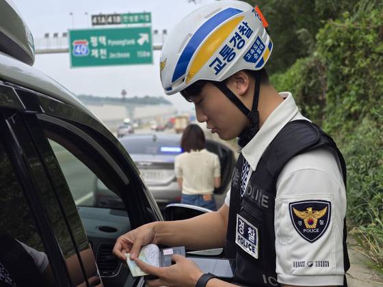 경기남부경찰청 고속도로순찰대 경찰관이 2일 오전 경부고속도로 서울방향 안성휴게소 부근에서 버스전용차로 위반 차량을 단속하고 있다. 손성배 기자